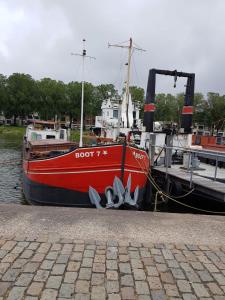 鹿特丹Boathotel Rotterdam Seven的一艘红色的船停靠在码头