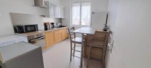 卡布尔Appartement 3 étoiles de 63m2的厨房配有冰箱和带凳子的台面