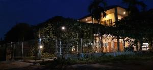 棉兰Bua Guest House的一座建筑,在晚上前有栅栏