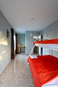 喀巴里特Wing Camp的客房设有两张双层床和一张红色沙发。