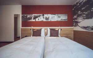 达沃斯Hotel Ochsen 2 by Mountain Hotels的红色墙壁的房间里一张大白色的床
