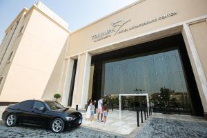 开罗Triumph Luxury Hotel的停在大楼前的一辆黑色汽车
