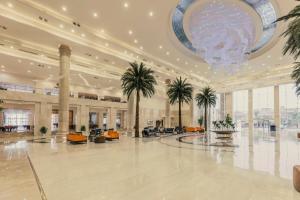 开罗Triumph Luxury Hotel的一个带棕榈树和吊灯的大型大堂