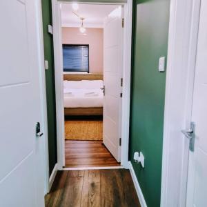 伦敦Beautiful Modern Apartment on Wick Lane的客房设有带床和绿色墙壁的卧室。