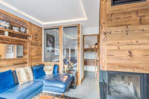 梅杰夫Appartement Perchets - Welkeys的客厅设有蓝色的沙发和壁炉