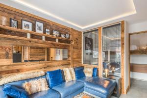 梅杰夫Appartement Perchets - Welkeys的客厅设有蓝色的沙发和木墙