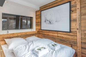 梅杰夫Appartement Perchets - Welkeys的一间卧室配有电视和一张白色床单。