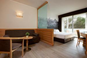 罗马阿兰公园西方酒店的酒店客房配有床、沙发和桌子。