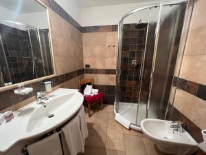 利维尼奥Hotel Le Alpi的一间带两个盥洗盆和淋浴的浴室