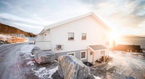 BrygghaugenDestination Senja - Vangsvik的前面有岩石的白色房子