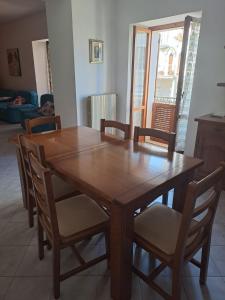SerramonacescaLa Casa di Serra的客厅配有一张木制餐桌和椅子