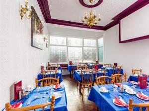 布莱克浦Holmeleigh Hotel的一间配备有蓝色桌椅的用餐室