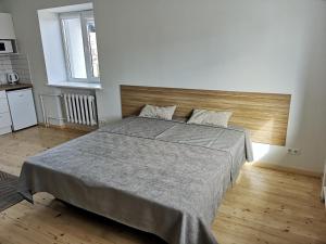 考纳斯COMFY Patogūs namai的一间卧室配有一张大床和木制床头板