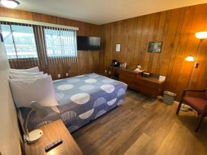 印第安河Waterway Inn的一间卧室配有一张床和一张带台灯的书桌