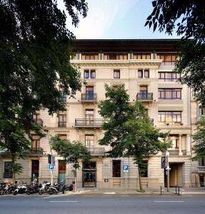 巴塞罗那HCC圣莫里茨酒店的一座大型建筑,前面停有摩托车