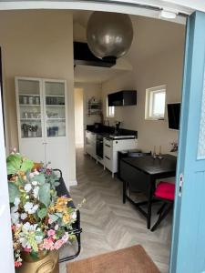 海牙Renovated & private Tinyhouse Den Haag short stay appartment的一间带桌子的客厅和一间厨房