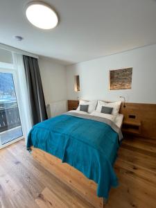马尔尼茨appartementsKOFLER的一间卧室配有一张带蓝色毯子的大床