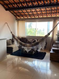 卡莫辛Ilha do amor的客厅配有吊床、沙发和窗户