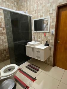 卡莫辛Ilha do amor的一间带卫生间、水槽和镜子的浴室