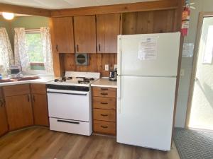 印第安河Waterway Inn的带木制橱柜的厨房内的白色冰箱