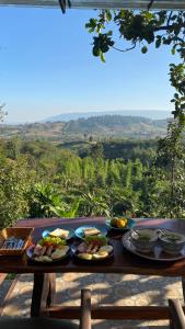 Ban Phu Hiภูคำฮ้อมคลิฟฟ์ลอดจ์ แอนด์ โฮมสเตย์ Phu come home cliff Lodge & Homestay的一张桌子,上面放着盘子,享有美景