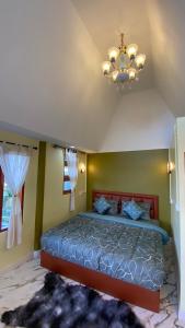 Ban Phu Hiภูคำฮ้อมคลิฟฟ์ลอดจ์ แอนด์ โฮมสเตย์ Phu come home cliff Lodge & Homestay的一间卧室配有一张床和一个吊灯