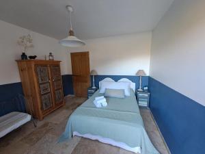 SarragiaFerme de Roccapina的蓝色的卧室配有床和沙发