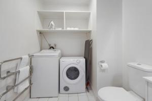 奥克兰CBD Stunner - Skytower View - WIFI - Netflix的白色的浴室设有洗衣机和卫生间。