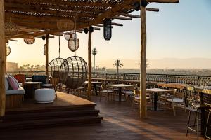 马拉喀什Nobu Hotel Marrakech的一间在甲板上配有桌椅的餐厅