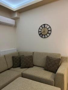科扎尼Kozani Home 01的客厅配有沙发和墙上的时钟