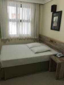 库里提巴爱斯塔克快捷酒店的一间卧室设有一张大床和窗户