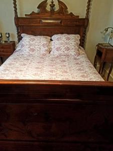 GagnyVilla Normandy的一间卧室配有一张木床和木制床头板