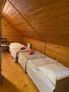 什切尔克Chata pod Skrzycznem LuLu的配有木天花板的客房内的两张床