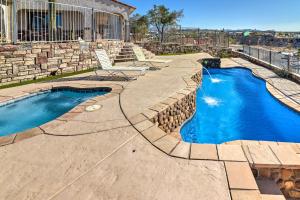 布尔海德市Bullhead City Home with Private Pool, Hot Tub and View的一座带石墙的庭院内的游泳池