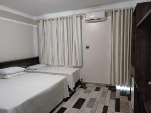 ArapongasLodi Express Hotel的酒店客房设有两张床和电视。