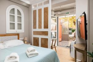 AnemómylosWell Apartments by Skyloft Corfu的一间卧室设有一张床和一个滑动玻璃门