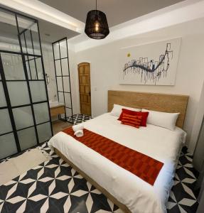 墨西哥城CASA LALIQUE的卧室配有带红色枕头的大型白色床