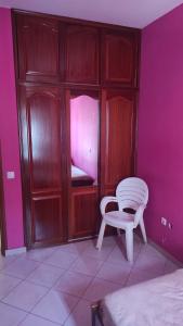 明德卢Casa de Gá的卧室配有白色椅子和粉红色墙壁