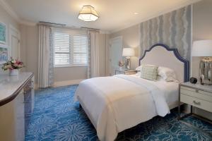 棕榈滩布雷克棕榈海滩酒店的卧室配有白色大床和蓝色地毯