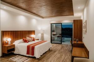 瓜达鲁佩镇Villa Montefiori的一间卧室设有一张大床和一个滑动玻璃门