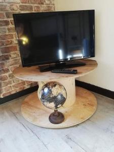 拉布尔布勒Le Nid douillet splendide的木桌上的电视,上面放着球