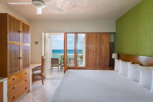 坎昆坎昆俱乐部里贾纳酒店的一间卧室配有一张床,享有海景