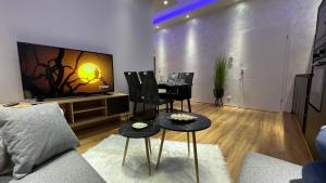维也纳D&D Schönbrunner Deluxe Apartment的客厅配有桌椅和电视。