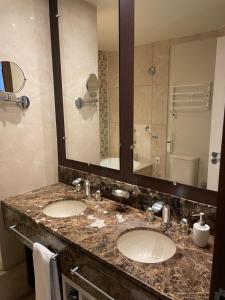 卡内拉Privilege Apart hotel Mountain Village的一间带两个盥洗盆和大镜子的浴室
