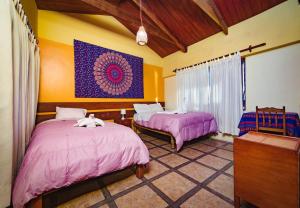 皮萨克查斯卡皮萨卡旅馆的一间卧室配有两张粉红色床单和绘画