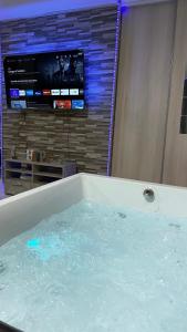塞夫朗Relax & Chill的客房内的浴缸里装满了水,配有电视
