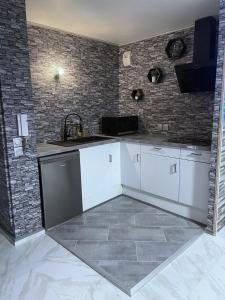 塞夫朗Relax & Chill的厨房配有白色橱柜和砖墙