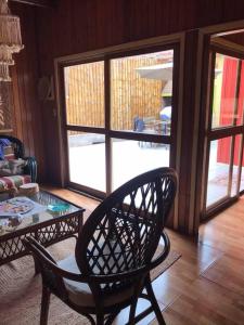 塞鲁阿苏尔La Casa Roja Cerro Azul的客厅配有椅子和玻璃桌