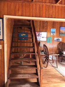 塞鲁阿苏尔La Casa Roja Cerro Azul的木楼梯,房间配有桌椅