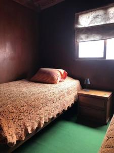 塞鲁阿苏尔La Casa Roja Cerro Azul的一间小卧室,配有床和窗户
